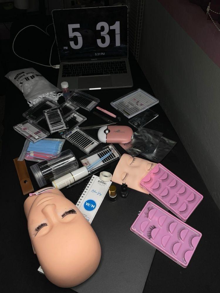 Lash studio workspace flatlay showing professional lash tools, tweezers, adhesive and supplies arranged neatly